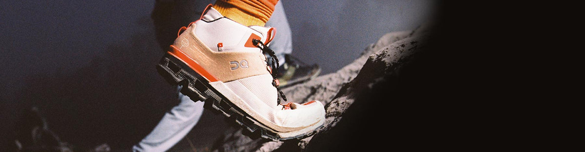 Close up of a person hiking up a rocky incline in On Cloudtrax hiking shoes.