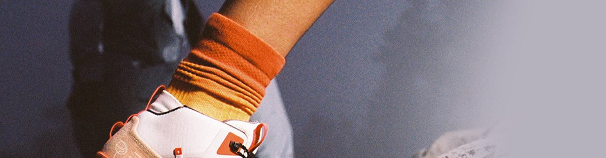 Closeup of a trail runner wearing Mango/Spice colored On Everyday Socks.