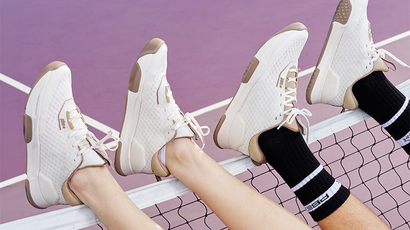 people wearing PB5Star Axis pickleball shoes with their feet propped up on a pickleball net on a purple court