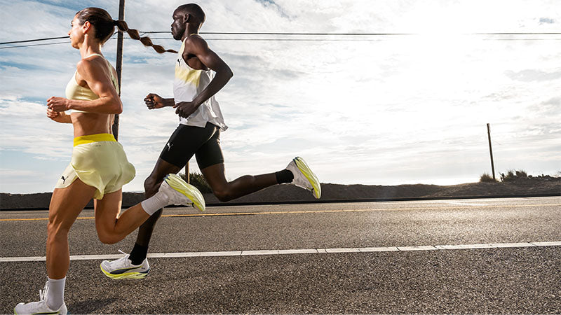 Two people running along a highway in Puma Deviate NITRO Elite running shoes