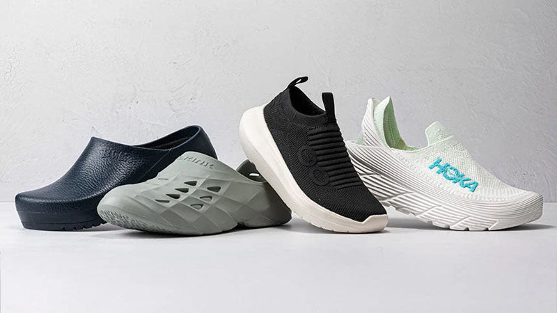 Four recovery shoes from different brands in different styles and colors displayed on a light gray background