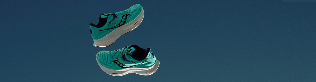 A pair of Saucony Ride 15 Cool Mint Women's running shoes floating against a dark sky blue background.