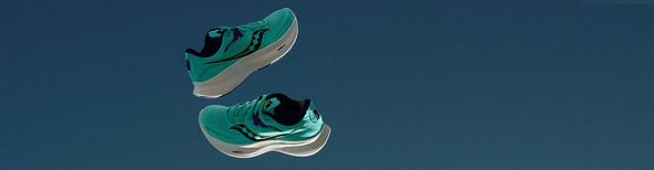 A pair of Saucony Ride 15 Cool Mint Women's running shoes floating against a dark sky blue background.