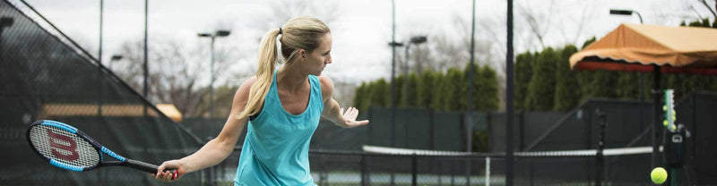 Woman striking tennis ball with Wilson tennis racquet