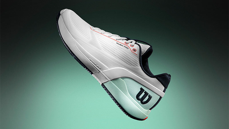White Wilson Rush Pro 5 tennis shoe with black, red and mint green accents on a gradient mint green background