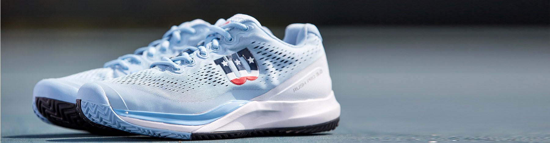 Wilson Rush Pro 3.0 Women's Chambry Blue/White/Outer Space pickleball shoes on a light blue outdoor court.