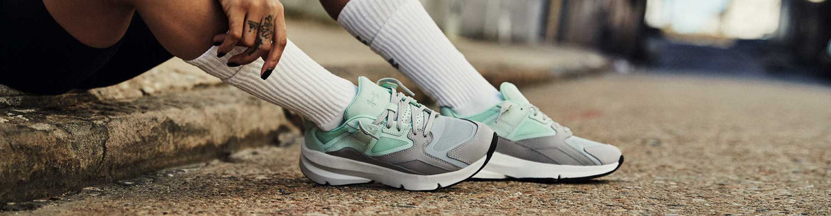 Woman in gray and blue Under Armour shoes
