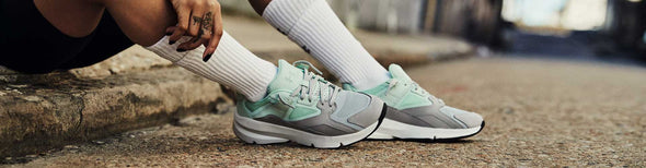 Woman in gray and blue Under Armour shoes