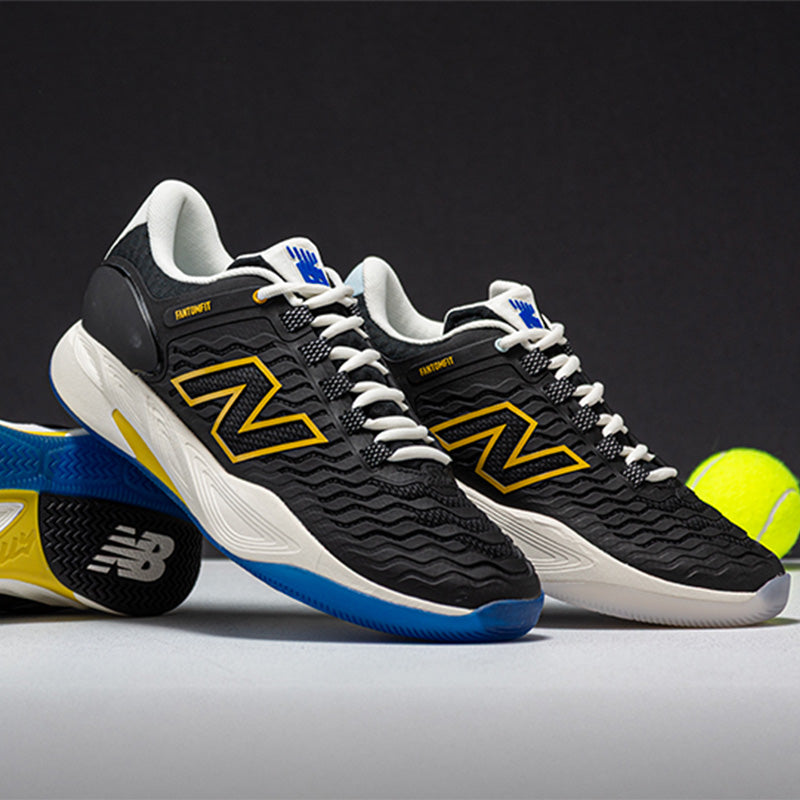Black and yellow New Balance Fresh Foam X CT Rally v2 tennis shoes with a tennis ball on a dark background