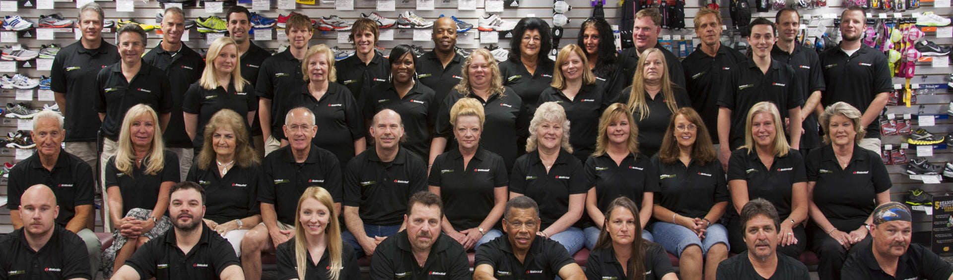 Group of Holabird Sports employees posing for a photograph, smiling in a coordinated and professional manner.