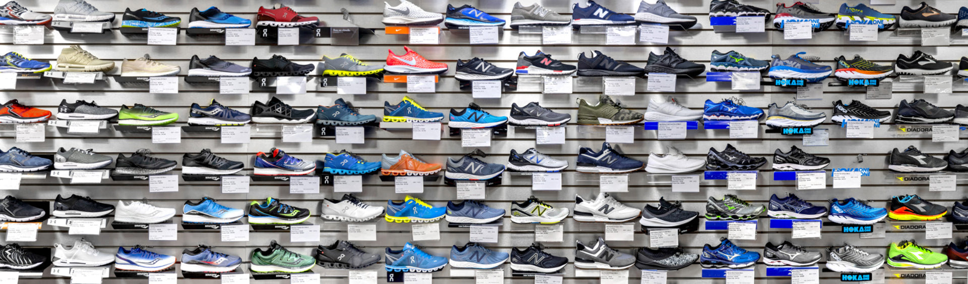 A display of athletic shoes showcasing a diverse collection of styles and colors, arranged neatly on a wall for customers to explore.