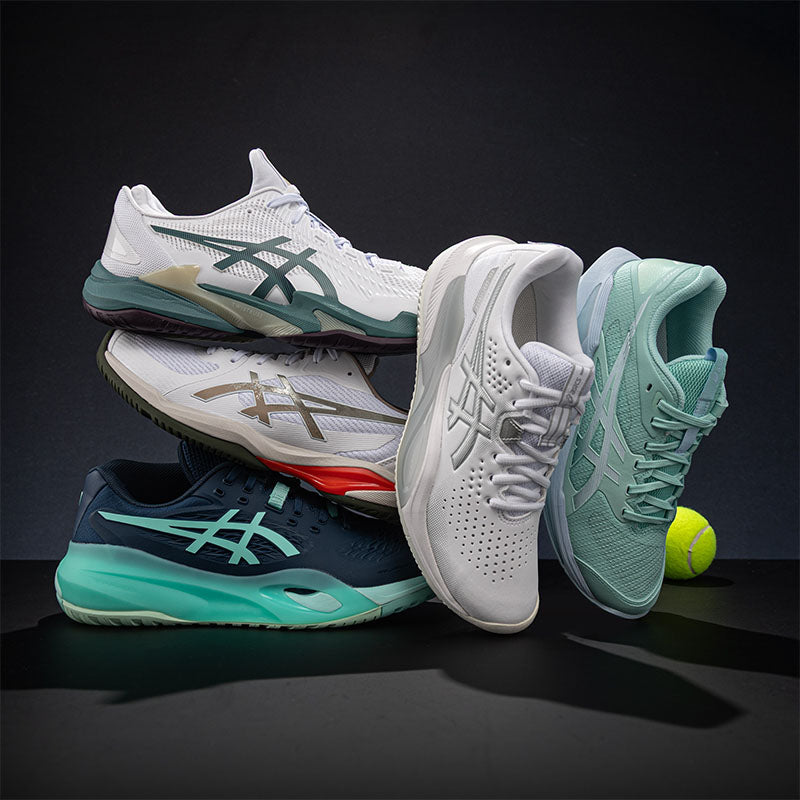 Five ASICS tennis shoes in different styles and colors stacked and posed on a dark studio background with a tennis ball.