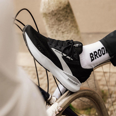 Person wearing black and white Brooks Adrenaline GTS 24 running shoes on a blurred background