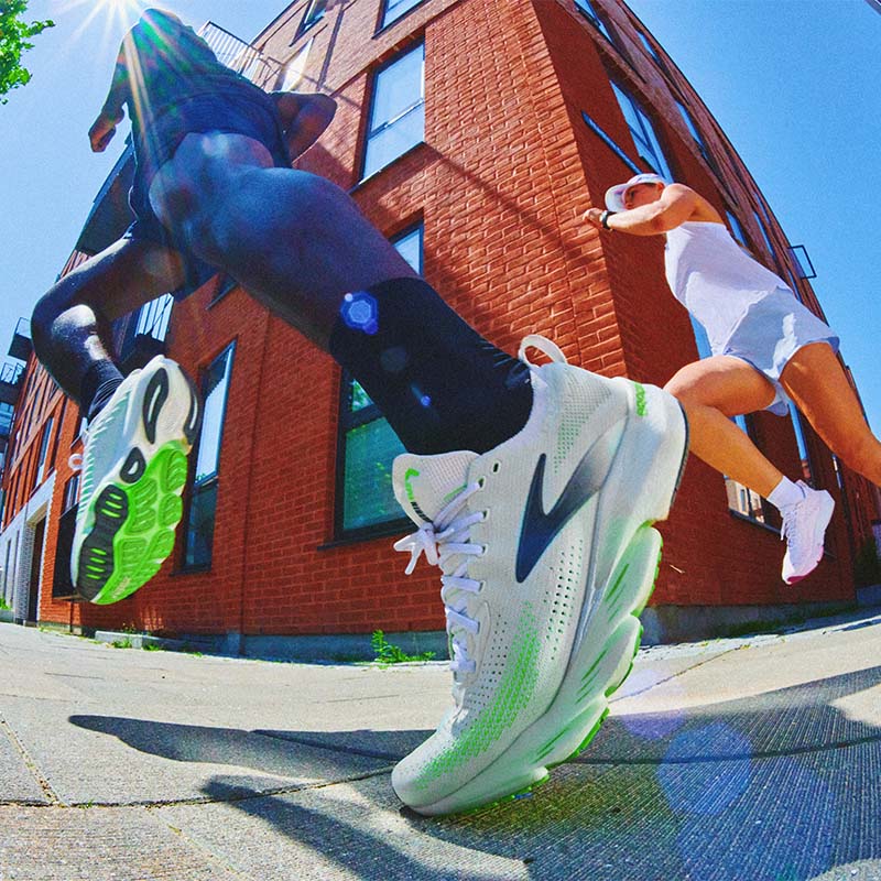 Image of runners in action wearing Brooks Glycerin Flex shoes on a sidewalk, in front of a four-story, red brick building.
