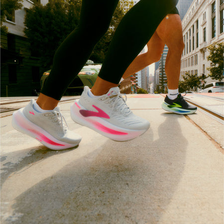 People running across a trolly track in a city wearing Brooks Glycerin Max 2 running shoes.