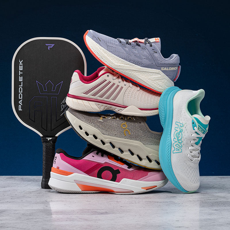 Stack of colorful sports shoes with a pickleball paddle on a dark blue background