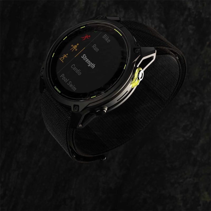 Black Garmin Enduro 3 GPS watch on a slightly blurred tree bark texture background