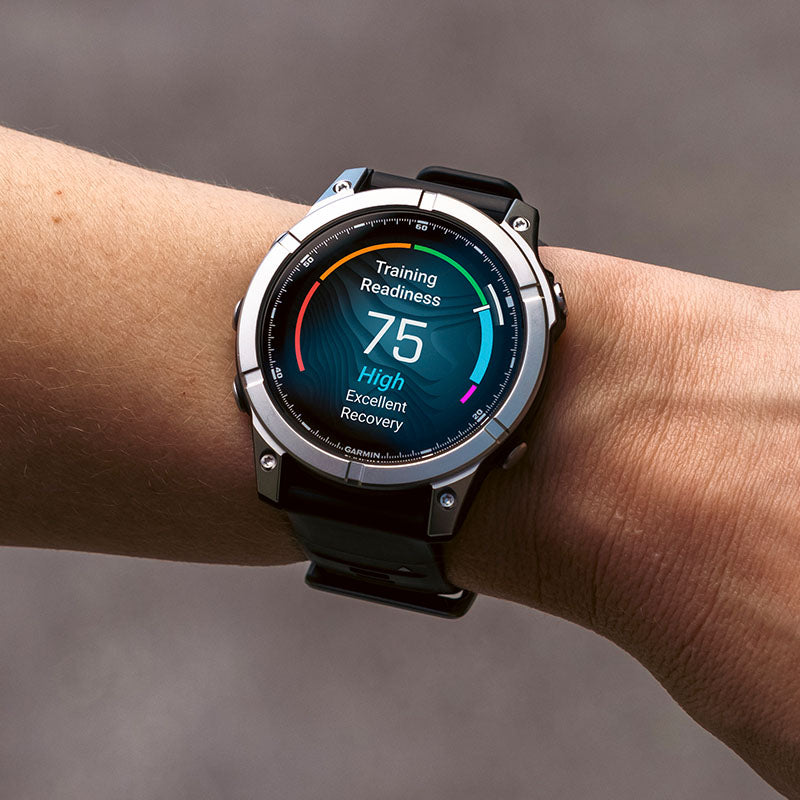 Garmin fenix E 47mm GPS watch on a wrist displaying health metrics against a blurred background