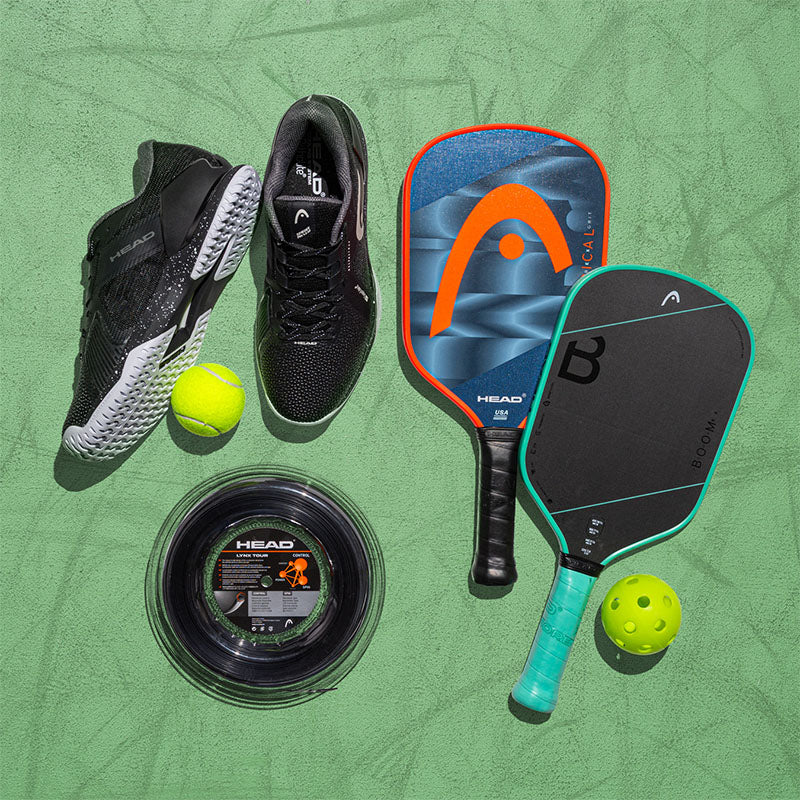 Assorted HEAD tennis and pickleball gear on a green court
