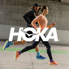 White HOKA logo layered over a lifestyle image of a man and woman running on a concrete pathway in HOKA Arahi 7 running shoes.