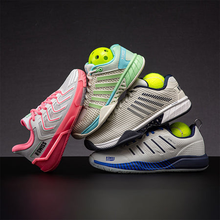 Four pairs of K-Swiss court shoes with tennis and pickleball balls on a dark background