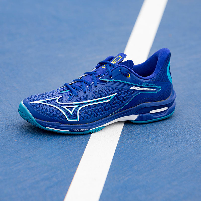Men's Mizuno tennis shoes on a blue court