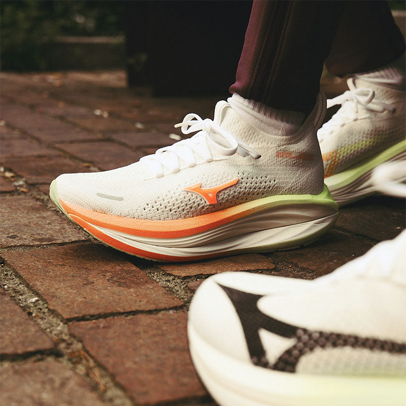 Close-up of people wearing Mizuno Neo Vista 3 running shoes on a brick path