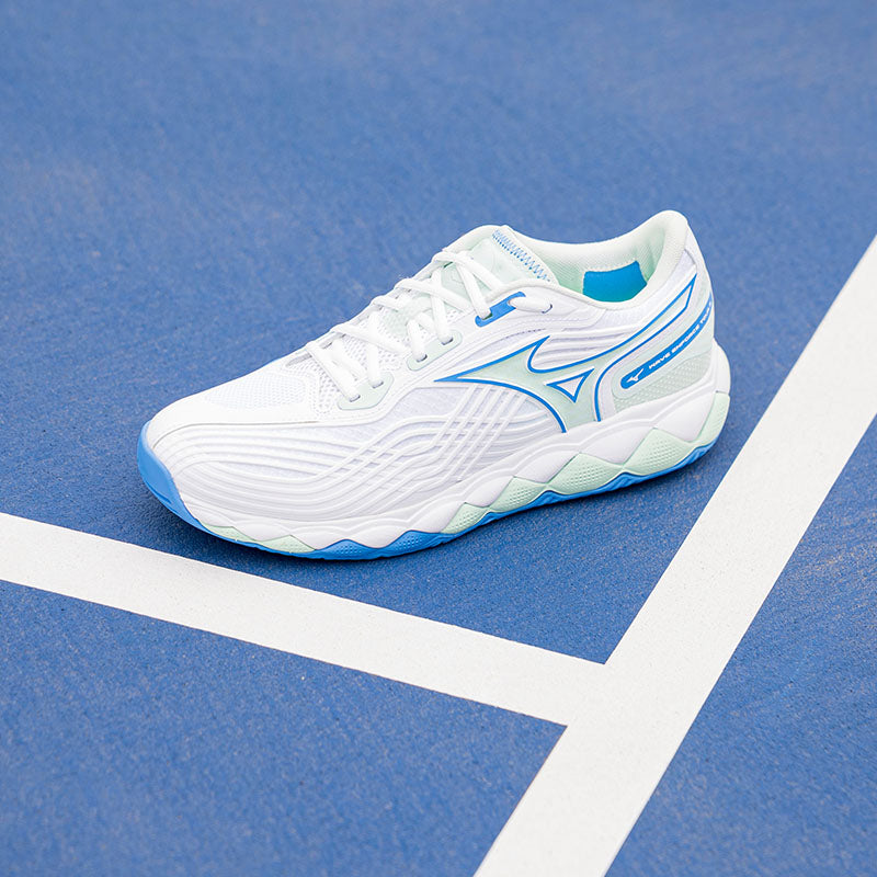 Women's Mizuno tennis shoes on a blue court