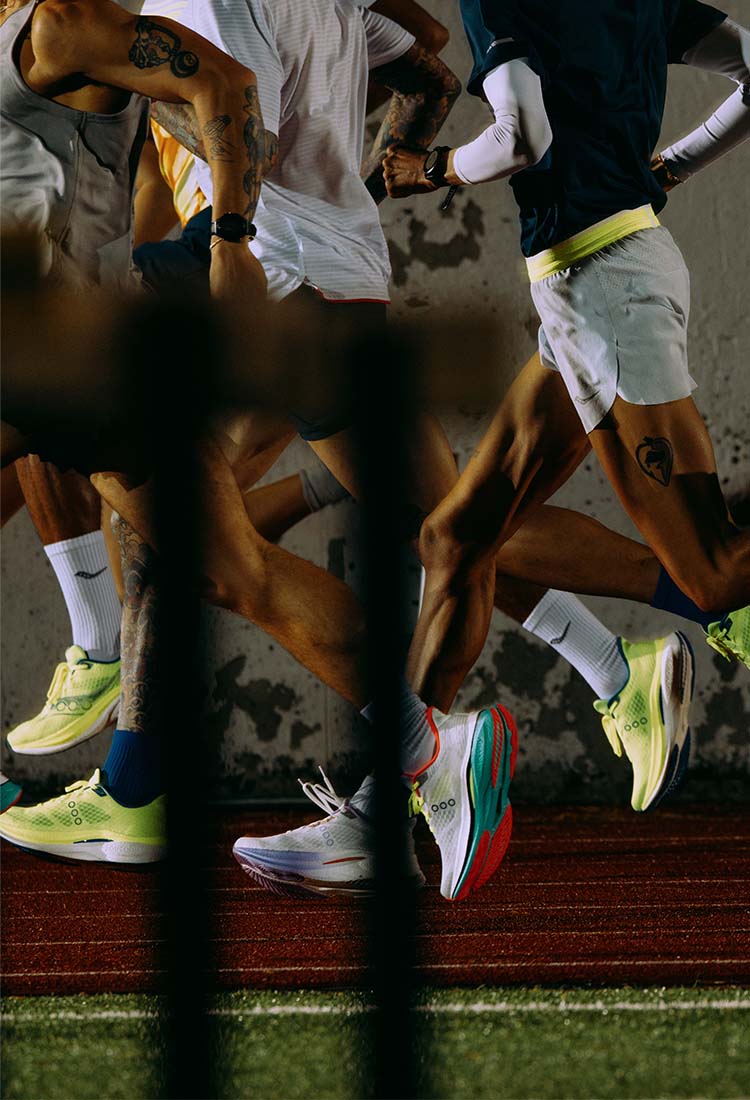 People running on a track at night wearing Saucony Endorphin Speed 5 running shoes