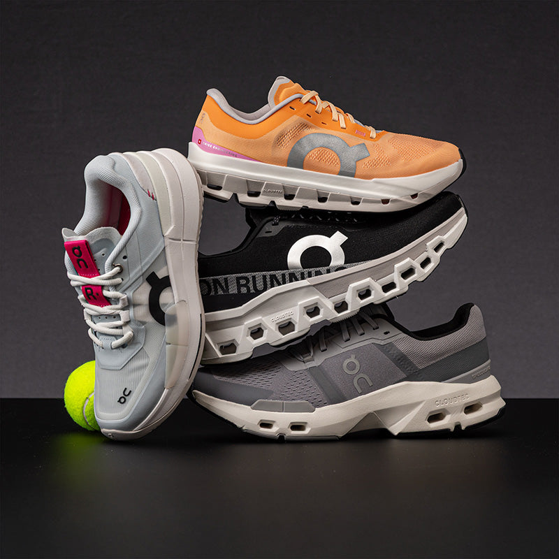 Stack of On shoes on a gray background with a tennis ball