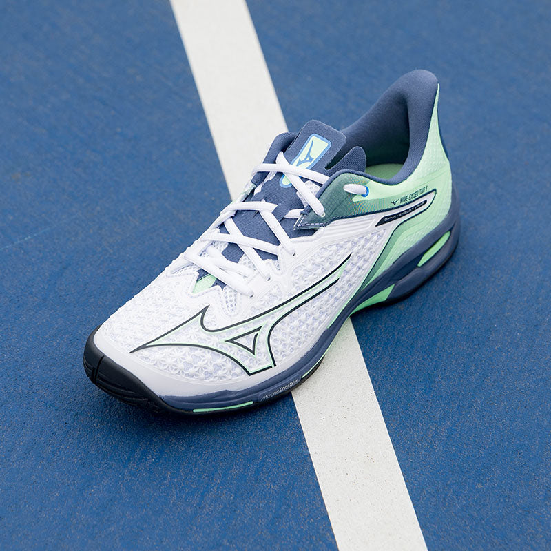 Mizuno tennis shoes on a blue court