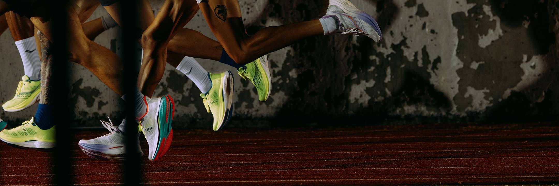 People running on a track at night wearing Saucony Endorphin Speed 5 running shoes