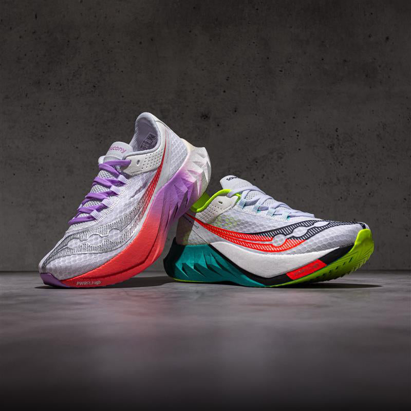 Colorful Saucony Endorphin Pro 4 running shoes on a dark concrete floor